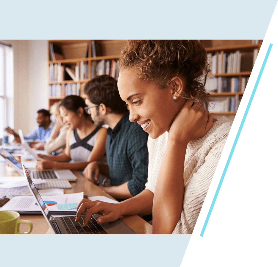A group of people sitting at tables with laptops.
